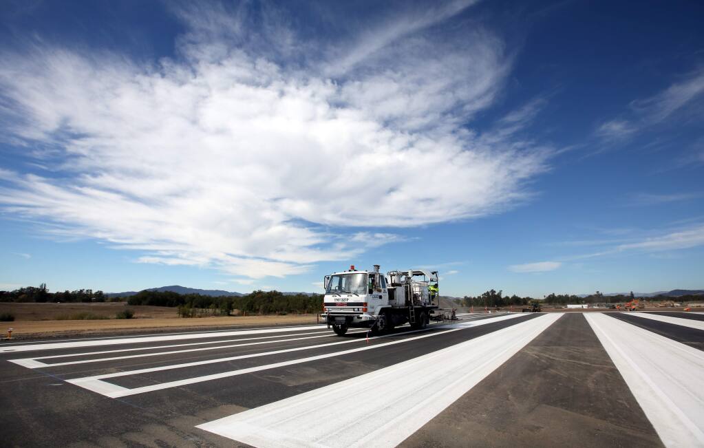 Maxwell Ashpalt paints the stripes during construction of the runway expansion project at the Charles M. Schulz-Sonoma County Airport on Tuesday, Oct. 7, 2014. (CRISTA JEREMIASON/ PD)
