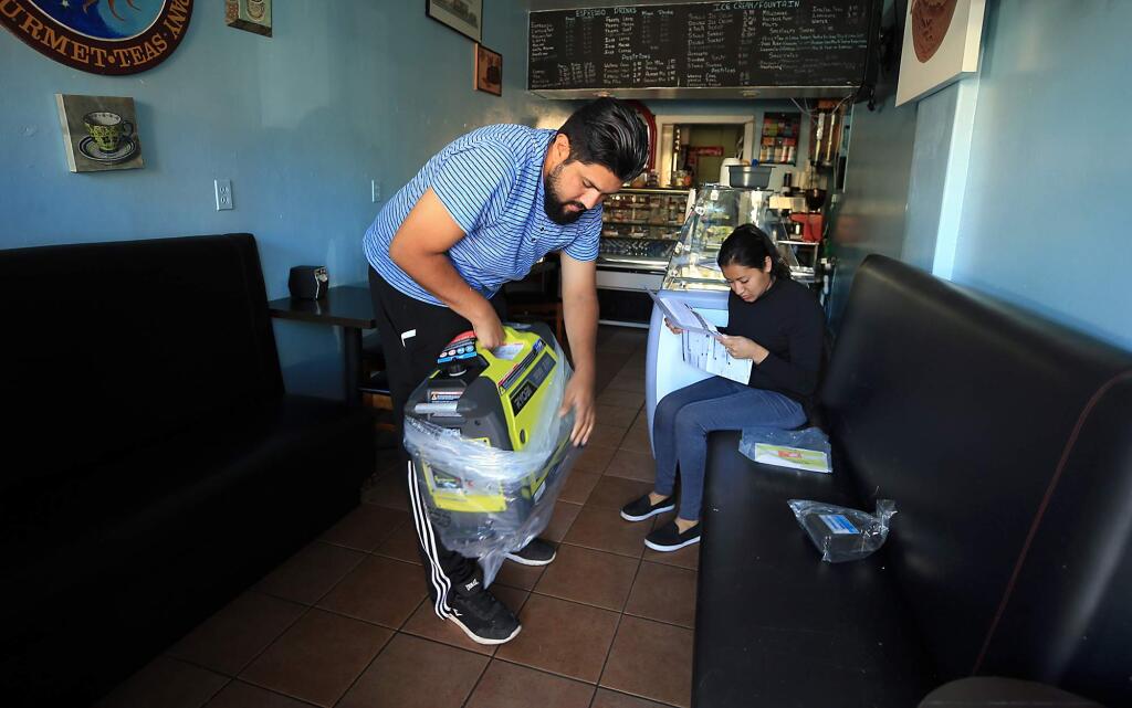 Andres and Yesina Hernandez bought a generator to preserve some of the inventory of their business, Cafe San Marcos, due to PG&E's fire preventative power outage in Calistoga on Monday, Oct. 15, 2018. (KENT PORTER/ PD)