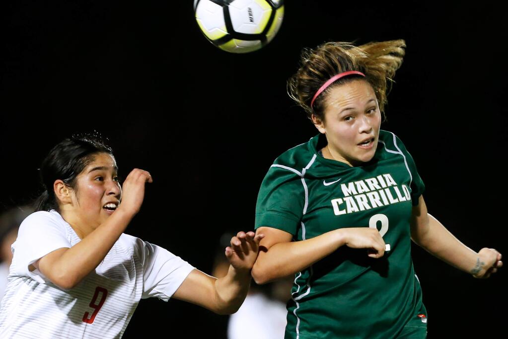 Maria Carrillo's Ashley Frye, right, heads the ball away from Montgomery's Angelica Barragan during the first half in Santa Rosa on Thursday, January 23, 2020. (Alvin Jornada / The Press Democrat)