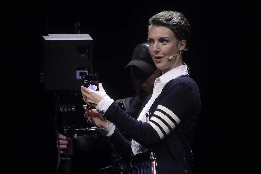 Rebecca Hirst, head of UK Mobile Product Development, holds a Samsung Galaxy Z Flip Phone while speaking at the Unpacked 2020 event in San Francisco, Tuesday, Feb. 11, 2020. (AP Photo/Jeff Chiu)
