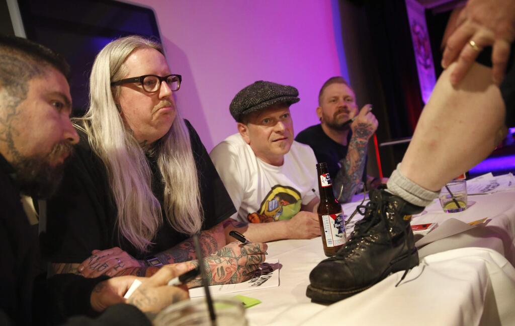 (From left) Judges Angel Gallardo, Donavan Kinyon, Mark Bode, and Scott Sprouse look at a tattoo of a cross with a bat on Christa Hillhouse's leg during the Ugly Tattoo Contest at Burgers & Vine on Sunday, March 22, 2015 in Sonoma, California . (BETH SCHLANKER/ The Press Democrat)