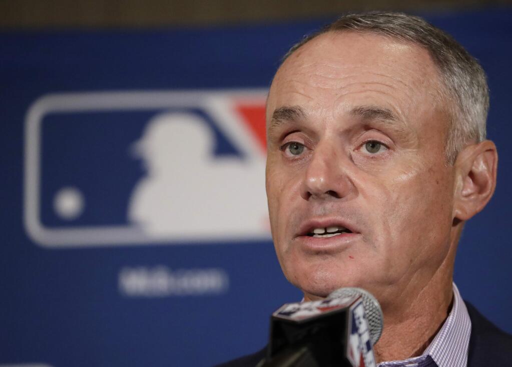 FILE - In this Feb. 21, 2017, file photo, Major League Baseball Commissioner Rob Manfred answers questions at a news conference in Phoenix. Baseball fans can like their team's games with a click starting Friday. Major League Baseball announced Facebook will carry a live game nationally each Friday starting with Colorado at Cincinnati this week. The Facebook package of 20 games will use the broadcast feed of one of the involved teams. Baseball Commissioner Rob Manfred made the announcement Thursday, May 18, 2017. He calls it 'really important for us in terms of experimenting with a new partner in this area.'(AP Photo/Morry Gash, File)