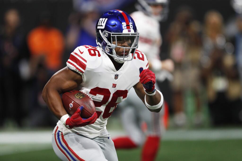 In this Monday, Oct. 22, 2018, file photo, New York Giants running back Saquon Barkley runs against the Atlanta Falcons during the first half in Atlanta. (AP Photo/John Bazemore, File)