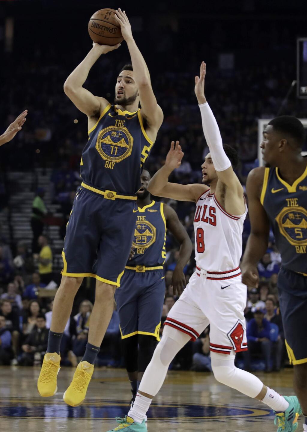 Golden State Warriors' Klay Thompson, left, shoots past Chicago Bulls' Zach LaVine (8) during the first half of an NBA basketball game Friday, Jan. 11, 2019, in Oakland, Calif. (AP Photo/Ben Margot)