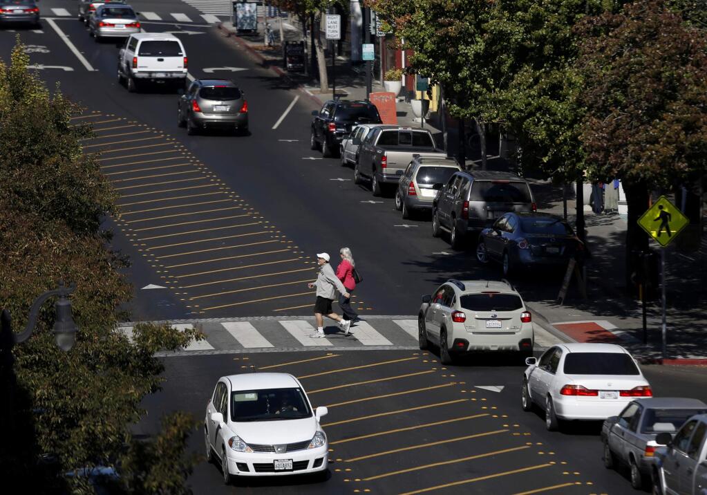 Pedestrians cross Petaluma Boulevard. (BETH SCHLANKER / The Press Democrat, 2013)