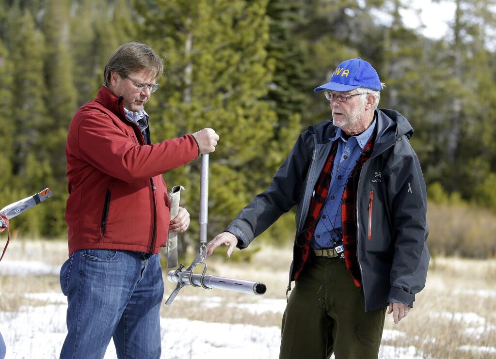 Frank Gehrke, chief of the California Cooperative Snow Surveys Program for the Department of Water Resources, right, checks the weight of the snow survey sample on a scale held by Grant Davis, director of the Dept. of Water Resources, while conducting the first snow survey of the season at the Phillips Station snow course, Wednesday, Jan. 3, 2018, near Echo Summit, Calif. The snow survey showed the snow pack at this location at 1.3 inches of depth with a water content of .4 inches. California's water managers are saying it's too early yet for fears that the state is sliding back into its historic five-year drought. (AP Photo/Rich Pedroncelli)