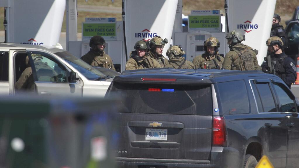 Royal Canadian Mounted Police officers prepare to take a person into custody at a gas station in Enfield, Nova Scotia on Sunday April 19, 2020. A suspect in an active shooter investigation is in custody in Nova Scotia, with police saying several people were harmed before a man wearing police clothing was arrested. Gabriel Wortman was arrested by the RCMP at the Irving Big Stop in Enfield, N.S., about 35 km from downtown Halifax. (Tim Krochak/The Canadian Press via AP)