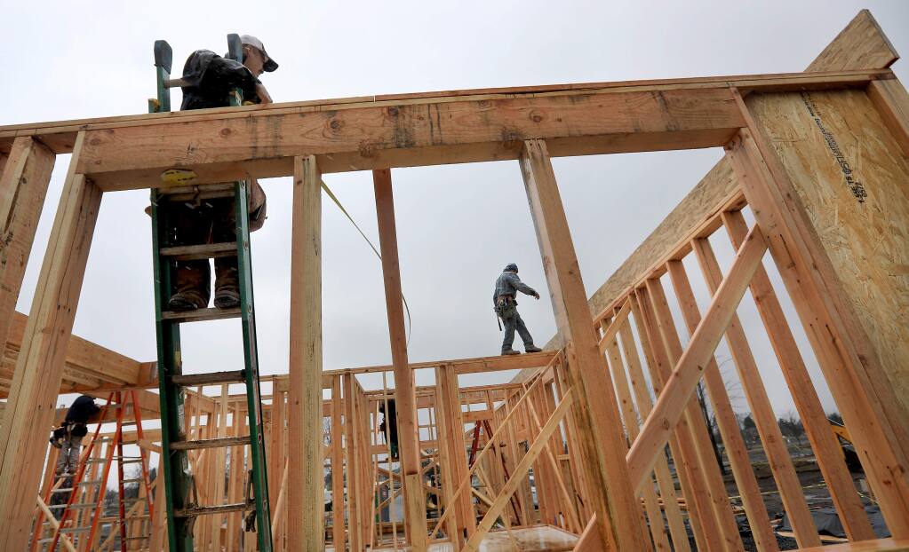 Workers with Pierre Homes prepare to put the second floor on an Astaire Court home in Coffey Park, Friday March 2, 2018 in Santa Rosa. (Kent Porter / Press Democrat) 2018