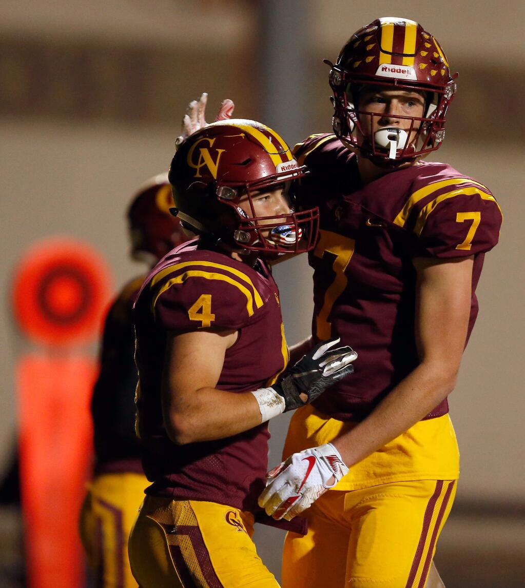 Cardinal Newman's Shane Moran (4), left, is congratulated after scoring a touchdown by teammate Jake Woods (7) during the first half of the NCS Division III playoff football game between Encinal and Cardinal Newman high schools, in Santa Rosa, California, on Saturday, November 24, 2018. (Alvin Jornada / The Press Democrat)