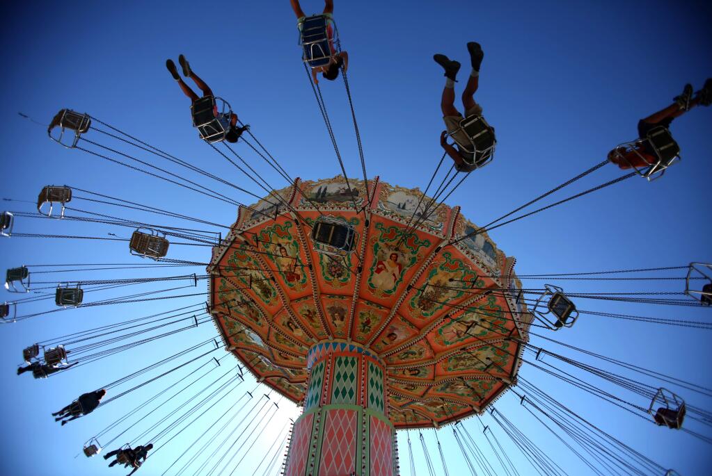 People ride the Wave Swinger at the Sonoma County Fair in 2014. (CRISTA JEREMIASON/ PD FILE)