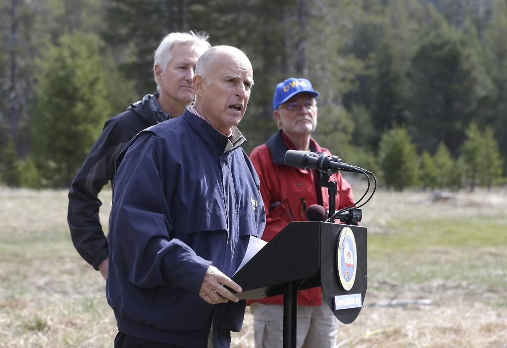 Gov. Jerry Brown, center, answers a question concerning the executive order he signed requiring the state water board to implement measures in cities and towns to cut water usage by 25 percent compared with 2013 levels, at Echo Summit, Calif., Wednesday, April 1, 2015. (AP Photo/Rich Pedroncelli)
