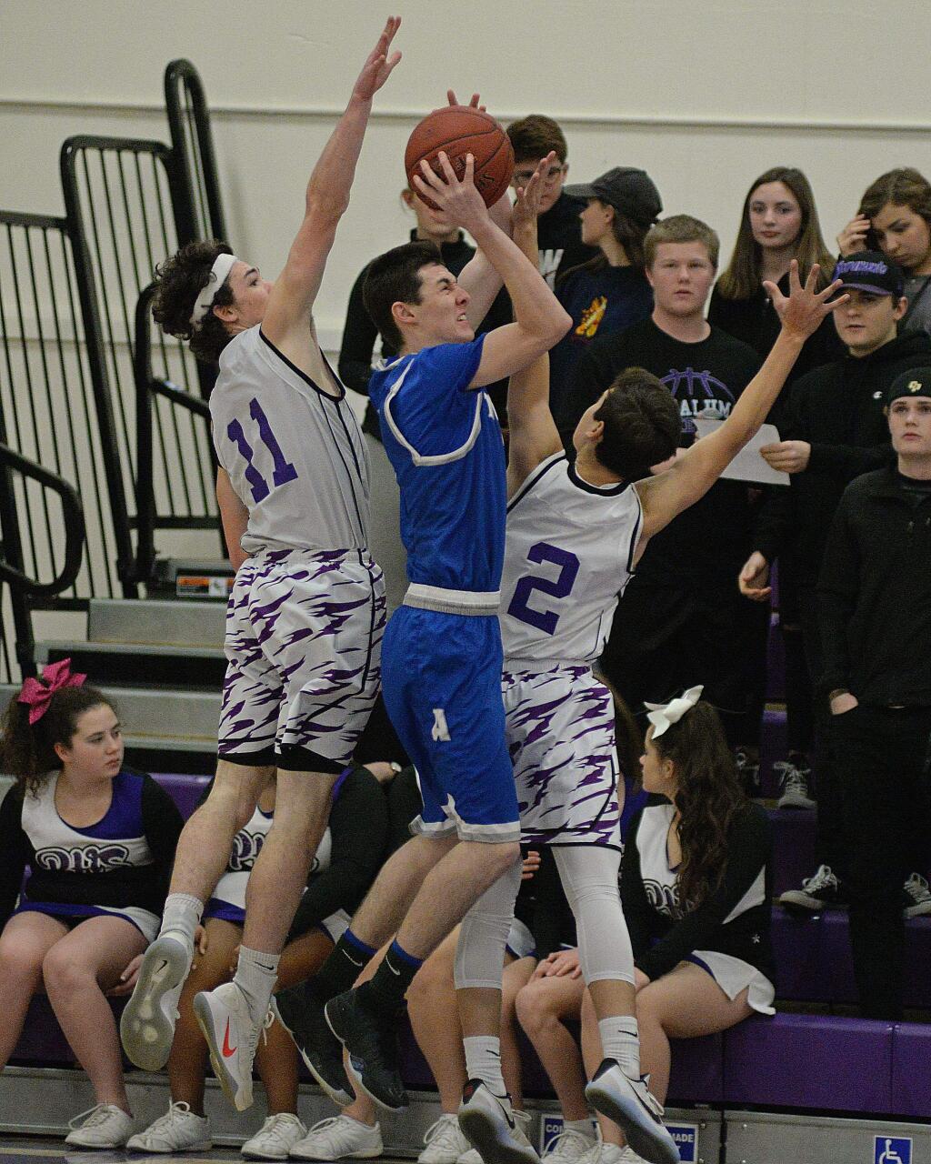 SUMNER FOWLER/FOR THE ARGUS-COURIERPetaluma's Brendan O'Neill and Austin Paretti sandwich an Analy shooter in SCL game won by Analy, 53-39.