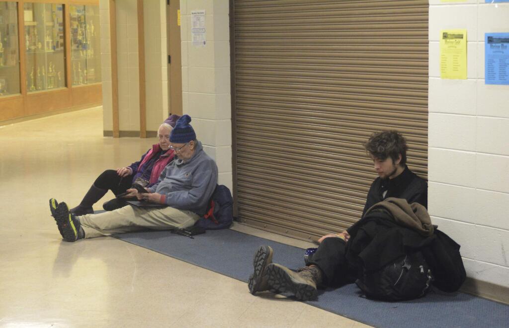 Jan Knutson, left, and her husband Ed Hutchinson, center, and a man at about 2:30 a.m. Tuesday, Jan. 23, 2018, wait for the all-clear at Homer High School during a tsunami alert for Homer, Alaska. The city of Homer issued an evacuation order for low-lying areas shortly after an earthquake hit. (Michael Armstrong/Homer News via AP)