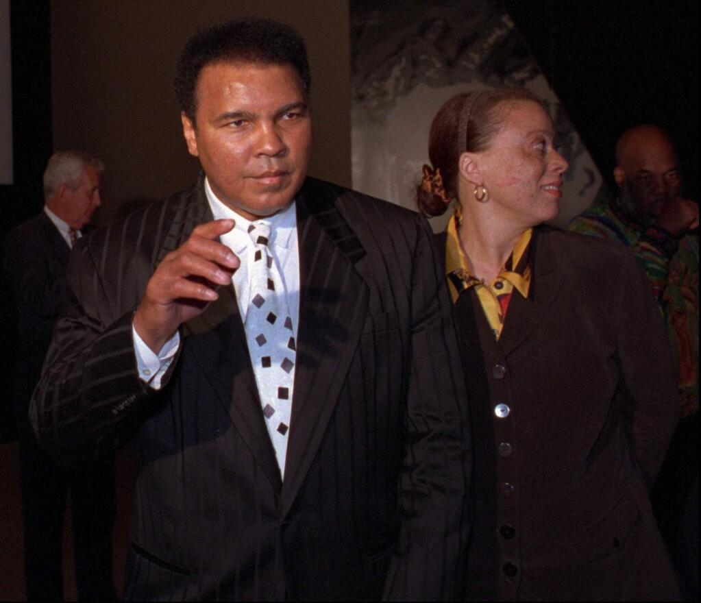 Muhammad Ali waves to a waiting crowd as he enters a theatre with his wife, Lonnie, Thursday, Feb. 27, 1997, in Louisville, Ky. Ali was on hand to watch the premier of 'When We Were Kings,' a film about Ali's fight with George Foreman. The film took two decades to reach the big screen. (AP Photo/Michael Clevenger)
