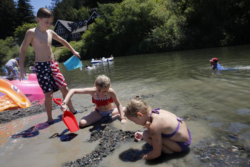 (From left) Chase Dinkel, Lexi Morrison, and MaryKate MacDonald play in the rocks and water during the Fourth of July celebration at Monte Rio Beach on Saturday, July 4, 2015 in Monte Rio. (BETH SCHLANKER / The Press Democrat)
