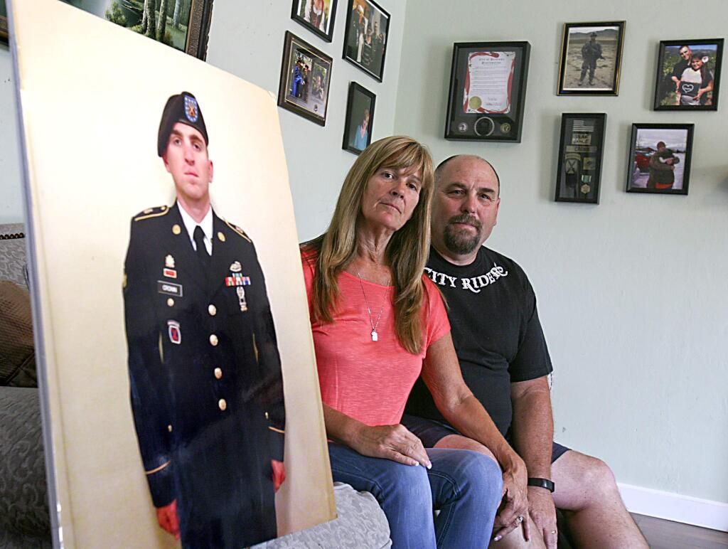 Jocelyn and John Cronin with a photo of their son Sam, who will soon leave for duty in Afghanistan, in their Petaluma home on Tuesday July 15, 2014. The Cronin's want to put their son's photo along with photos of other Petalumans serving their country on banners flying above the streets of Petaluma.