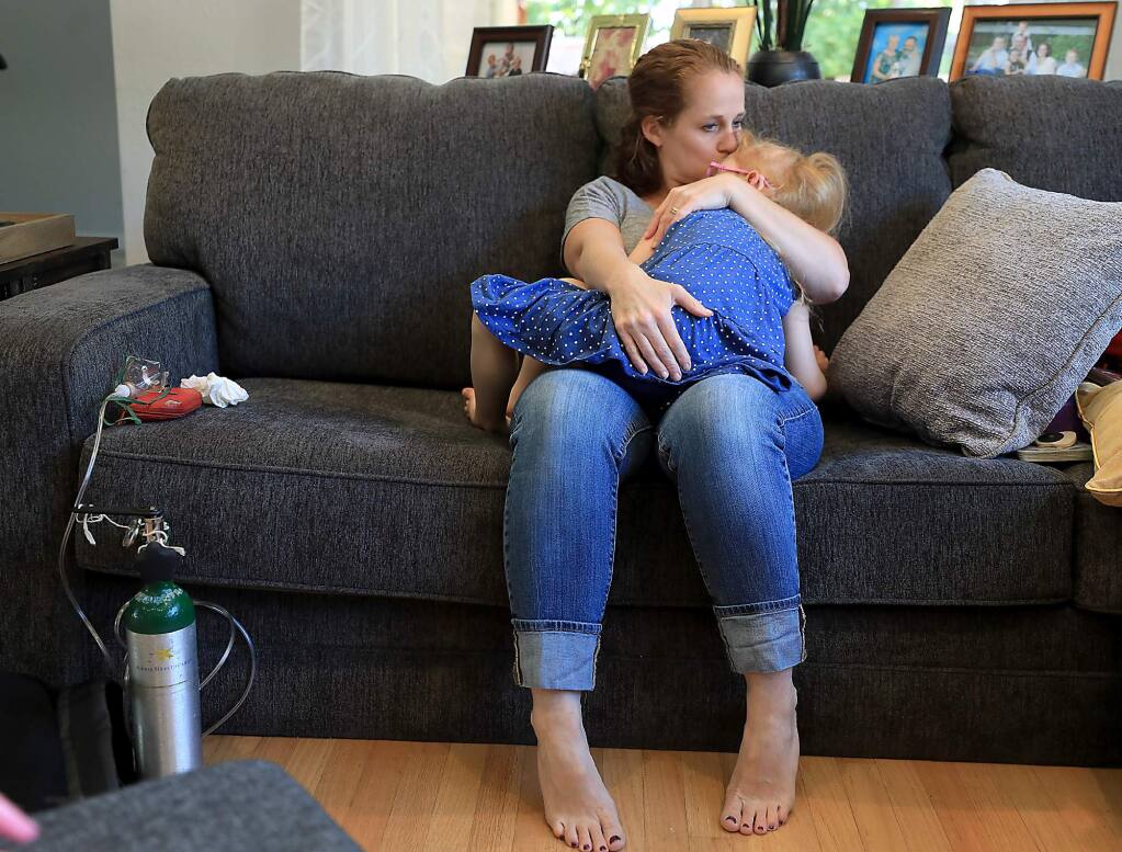 As Brooke Adams, 5, comes back from a seizure, her mother Jana calms her after administering a cannabis-based medication (CBD) and oxygen, Monday, July 23, 2018 at their home in Santa Rosa. Brooke has Dravet Syndrome, a rare genetic dysfunction of the brain. The CBD cuts the seizing to just minutes. (KENT PORTER/ PD)
