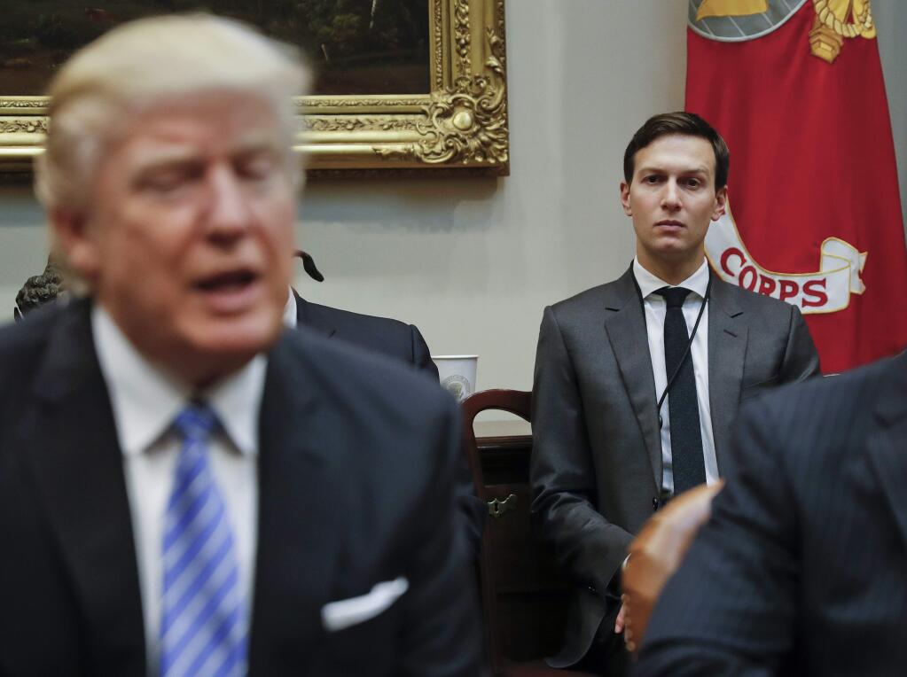 FILE - In this Monday, Jan. 23, 2017, file photo, White House Senior Adviser Jared Kushner, right, listens to President Donald Trump speak during a breakfast with business leaders in the Roosevelt Room of the White House in Washington. Trump is set to announce a new White House office run by his son-in-law, Kushner, that will seek to overhaul government functions using ideas from the business sector. (AP Photo/Pablo Martinez Monsivais, File)