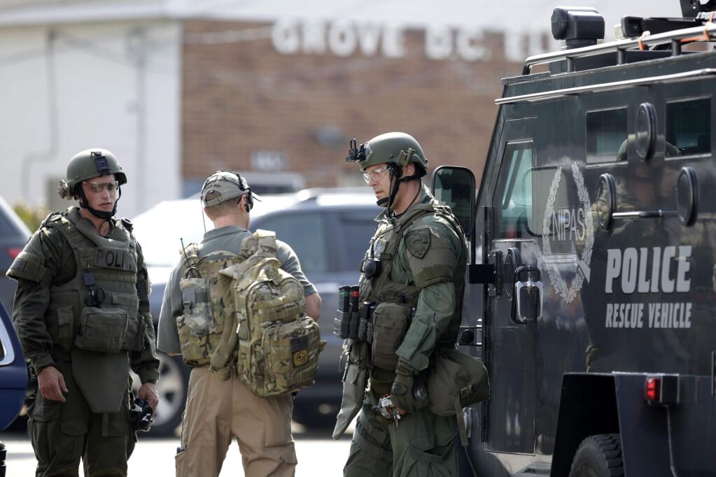 Police officers gather before heading out for a manhunt after an officer was shot in Fox Lake, Ill., on Tuesday, Sept. 1, 2015. Lake County Major Crimes Task Force Cmdr. George Filenko says an officer was shot Tuesday morning in Fox Lake, 55 miles north of Chicago. (Stacey Wescott/Chicago Tribune via AP)