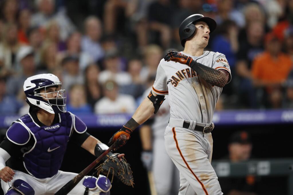 The San Francisco Giants' Mike Yastrzemski watches his two-run home run next to Colorado Rockies catcher Tony Wolters during the fifth inning Friday, Aug. 2, 2019, in Denver. (AP Photo/David Zalubowski)