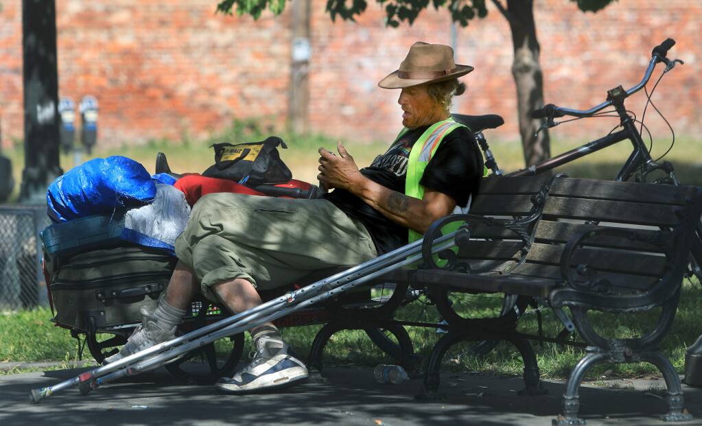 Patrick Donohue, attempting to get his phone to function, is originally from Santa Cruz, and has been homeless off and on in Santa Rosa, Thursday, June 27, 2019. Donohue keeps coming back to Santa Rosa because the people here are 'Really nice,' he says.(Kent Porter / The Press Democrat) 2019