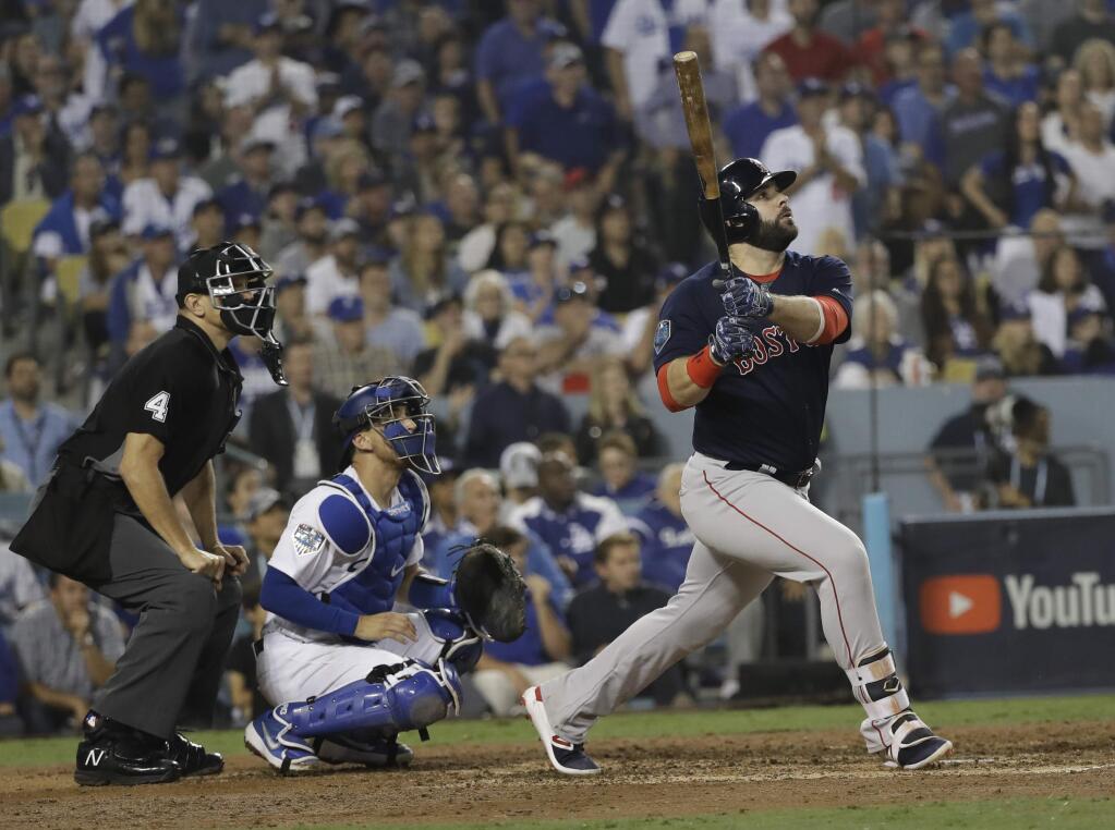 Boston Red Sox's Mitch Moreland watches his three-run home run during the seventh inning in Game 4 of the World Series baseball game against the Los Angeles Dodgers on Saturday, Oct. 27, 2018, in Los Angeles. Left is home plate umpire Chad Fairchild and Los Angeles Dodgers catcher Austin Barnes. (AP Photo/David J. Phillip)