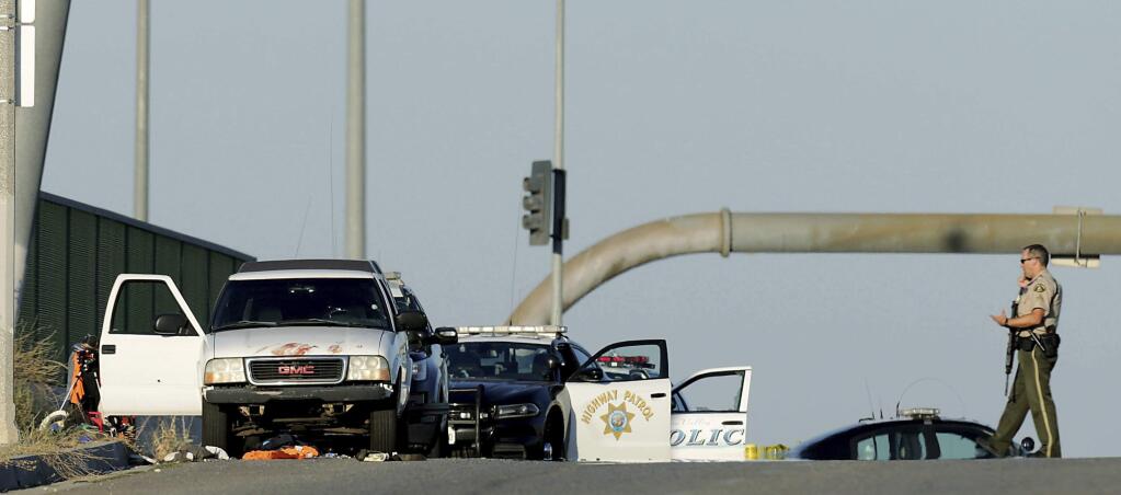 Authorities investigate the scene on the Eastridge Avenue overpass over Interstate 215, where a fatal shootout occurred, Monday, Aug. 12, 2019, in Riverside, Calif. (Terry Pierson/The Orange County Register via AP)