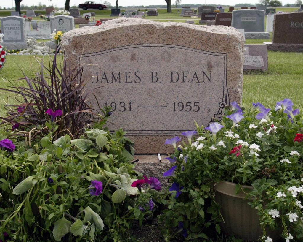 FILE - This May 27, 2005 file photo shows plants and flowers at the grave of actor James Dean in Fairmount, Ind. Dean hasn't been alive in 64 years, but the “Rebel Without a Cause” actor has been cast in a new film about the Vietnam War. The filmmakers behind the independent film “Finding Jack” said Wednesday that a computer-generated Dean will play a co-starring role in the upcoming production. The digital Dean is to be assembled through old footage and photos and voiced by another actor. (AP Photo/John Harrell, File)
