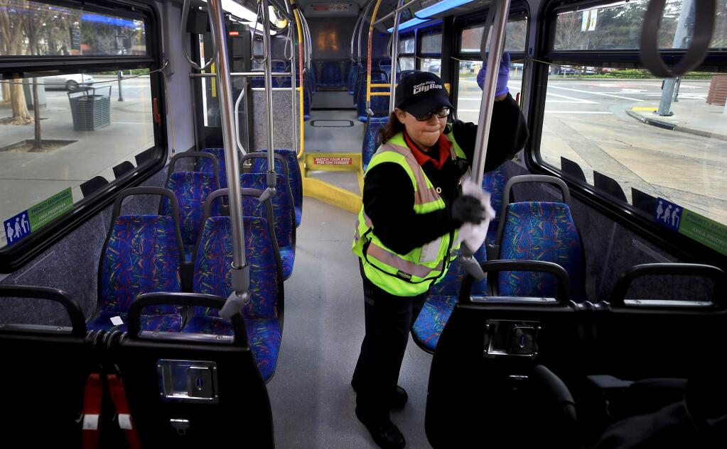 Irma Paredes disinfects the high traffic touch points on Santa Rosa city bus to help limit the possible spread of the novel coronavirus, Friday, March 6, 2020 at the transit mall in Santa Rosa. (Kent Porter / The Press Democrat) 2020