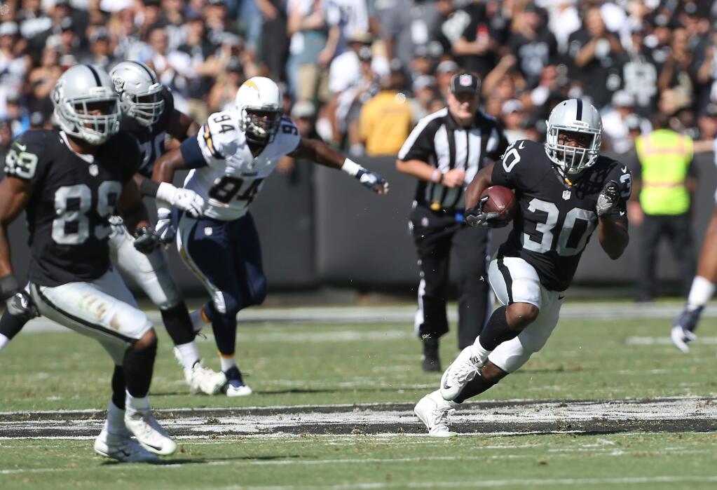 Oakland Raiders running back Jalen Richard takes the ball up the field against the San Diego Chargers, during their game in Oakland on Sunday, October 9, 2016. The Raiders defeated the Chargers 34-31.(Christopher Chung/ The Press Democrat)