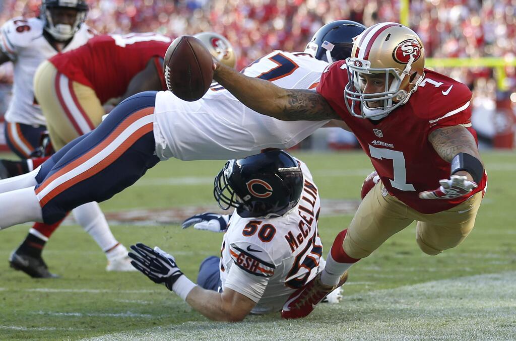 San Francisco 49ers quarterback Colin Kaepernick (7) is pushed out of bounds by Chicago Bears free safety Chris Conte, top, as Shea McClellin helps on defense during the first quarter of an NFL football game in Santa Clara, Calif., Sunday, Sept. 14, 2014. (AP Photo/Tony Avelar)
