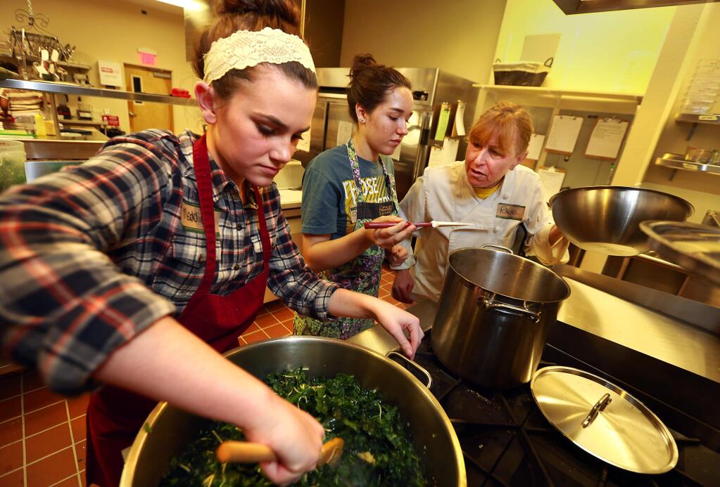 (l to r) Teen chefs Maddie Craig and Christina Alberigi. Donaldson work with mentor Rachel Bloom preparing meals for the seriously ill in the new Ceres Community Project kitchen at SAY's Dream Center. (JOHN BURGESS / The Press Democrat)