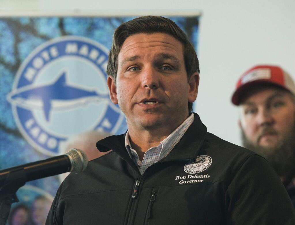 FILE - In this Jan. 10, 2019 file photo, Republican Gov. Ron DeSantis announces funding for his environmental policy during a press conference at Mote Marine Laboratory in Sarasota, Fla. DeSantis and the independently elected Cabinet granted pardons to four African-American men accused of raping a white woman nearly 70 years ago in a case now seen as a racial injustice. The unanimous vote came minutes after alleged victim Norma Padgett Upshaw pleaded with DeSantis and the Cabinet members, meeting as the clemency board, not to grant the pardons, saying she still relives the horror of the rape she said happened in 1949. But DeSantis said the case against the men known as the Groveland Four was clearly mishandled. (Dan Wagner/Sarasota Herald-Tribune via AP, File)