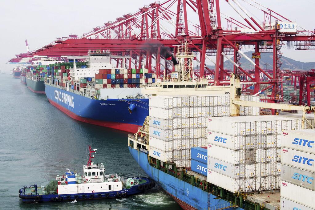 In this Wednesday, May 8, 2019, photo, a barge pushes a container ship to the dockyard in Qingdao in eastern China's Shandong province. President Donald Trump's latest tariff hikes on Chinese goods took effect Friday and Beijing said it would retaliate, escalating tensions in fight over China's technology ambitions and other trade strains. (Chinatopix via AP)