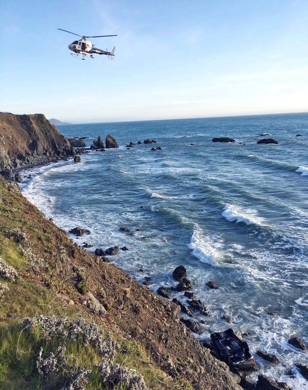 FILE - This March 27, 2018, file photo provided by the California Highway Patrol shows a helicopter hovering over steep coastal cliffs near Mendocino, Calif., where a vehicle, visible at lower right, plunged about 100 feet off a cliff along Highway 1, killing all passengers. (California Highway Patrol via AP, File)