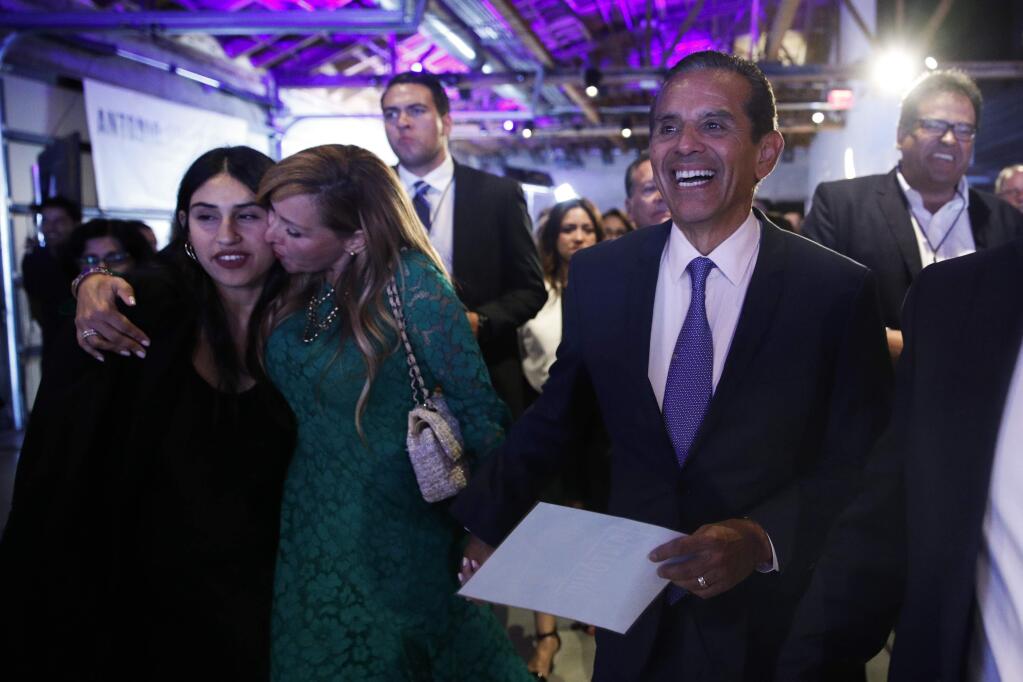 Gubernatorial candidate and former Los Angeles Mayor Antonio Villaraigosa, right, arrives to deliver a concession speech as wife, Patricia, second from left, kisses the candidate's daughter, Natalia, at an election-night watch party Tuesday, June 5, 2018, in Los Angeles. (AP Photo/Jae C. Hong)