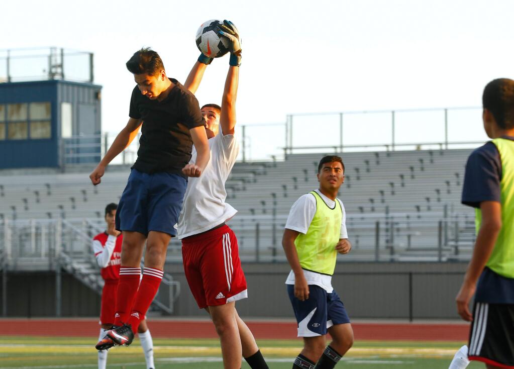 Rancho Cotate goalkeeper Christian Mendoza comes out to protect the goal from Memo Lojas on a corner kick drill during Rancho Cotate High School boys varsity soccer practice, in Rohnert Park, California on Thursday, November 19, 2015. (Alvin Jornada / The Press Democrat)