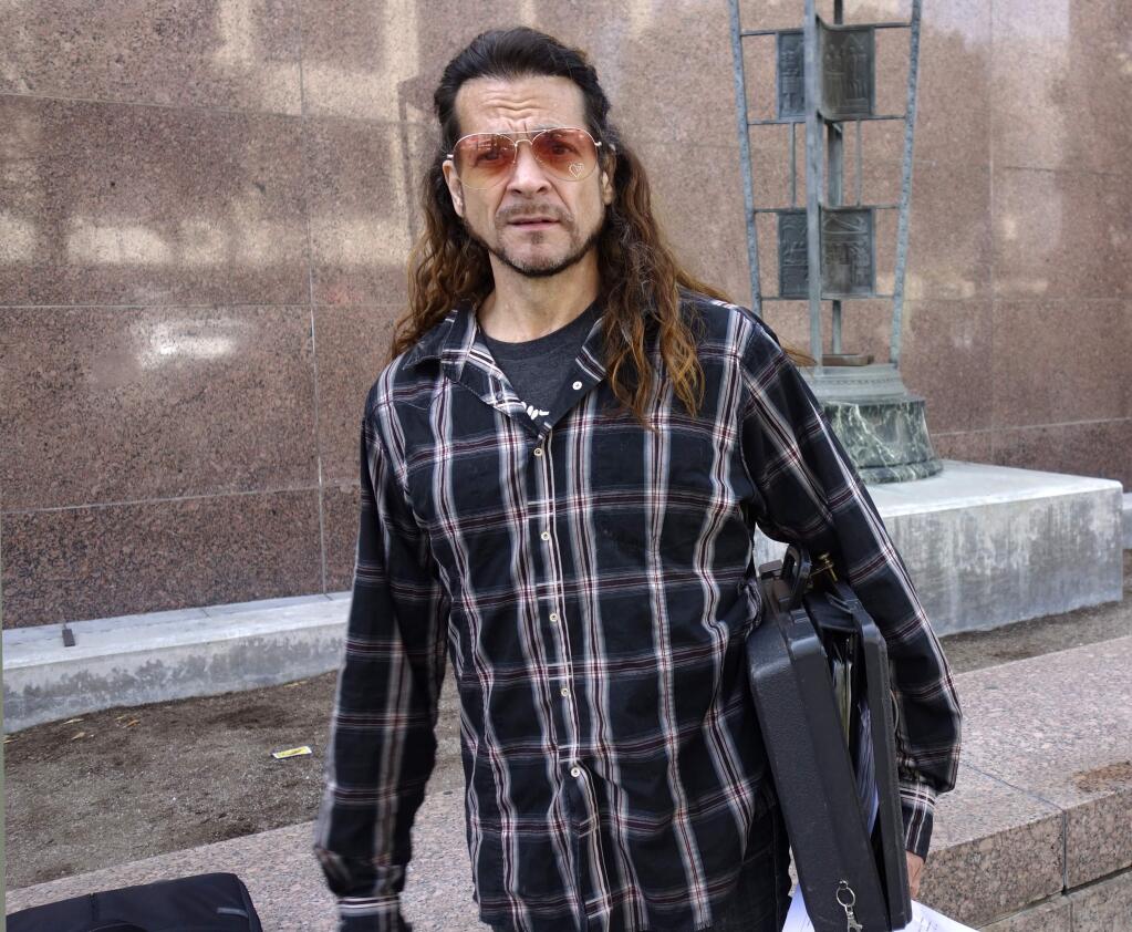 FILE - In this May 8, 2018 file photo, Matthew Lentz, who says he was fathered by convicted murderer Charles Manson at an orgy, stands outside Los Angeles Superior Court in Los Angeles. A Los Angeles judge has eliminated two purported sons of Charles Manson from the battle over his estate. Judge Clifford Klein dismissed the cases of Lentz, a musician who says he was fathered by Manson at a 1967 orgy, and Michael Brunner, whose mother was a member of the “Manson family.” (AP Photo/Brian Melley, file)
