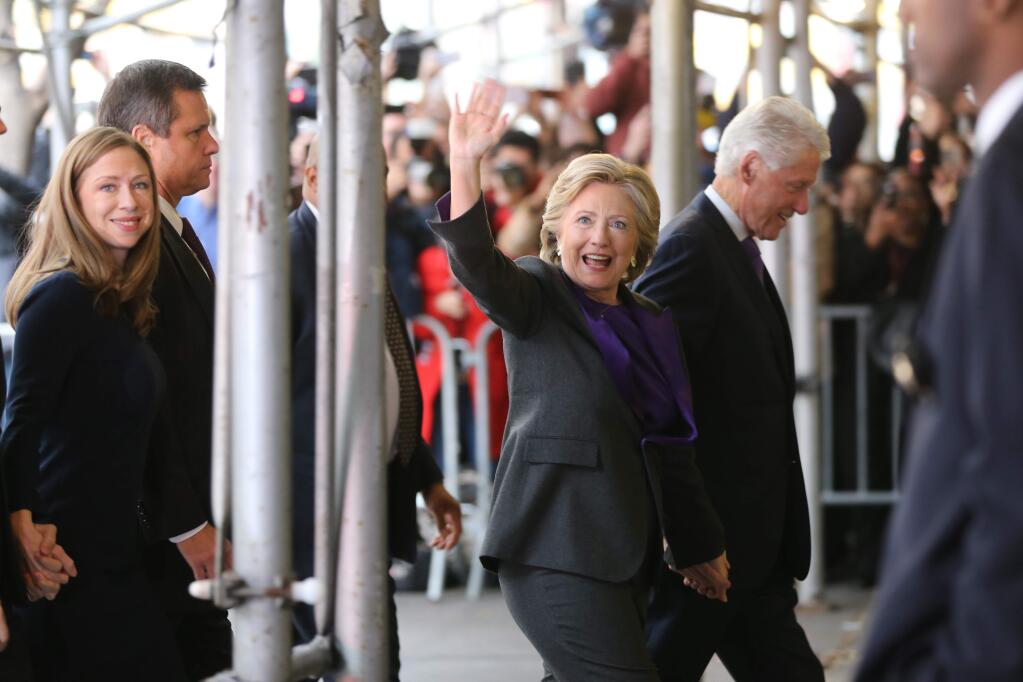 Hillary Clinton, holding hands with her husband, former President Bill Clinton, waves to a crowd outside a New York hotel as she arrives to speak to her staff and supporters after losing the race for the White House, Wednesday, Nov. 9, 2016. At left is their daughter, Chelsea Clinton. Earlier in the day she conceded the race to Republican president-elect Donald Trump. (AP Photo/Seth Wenig)