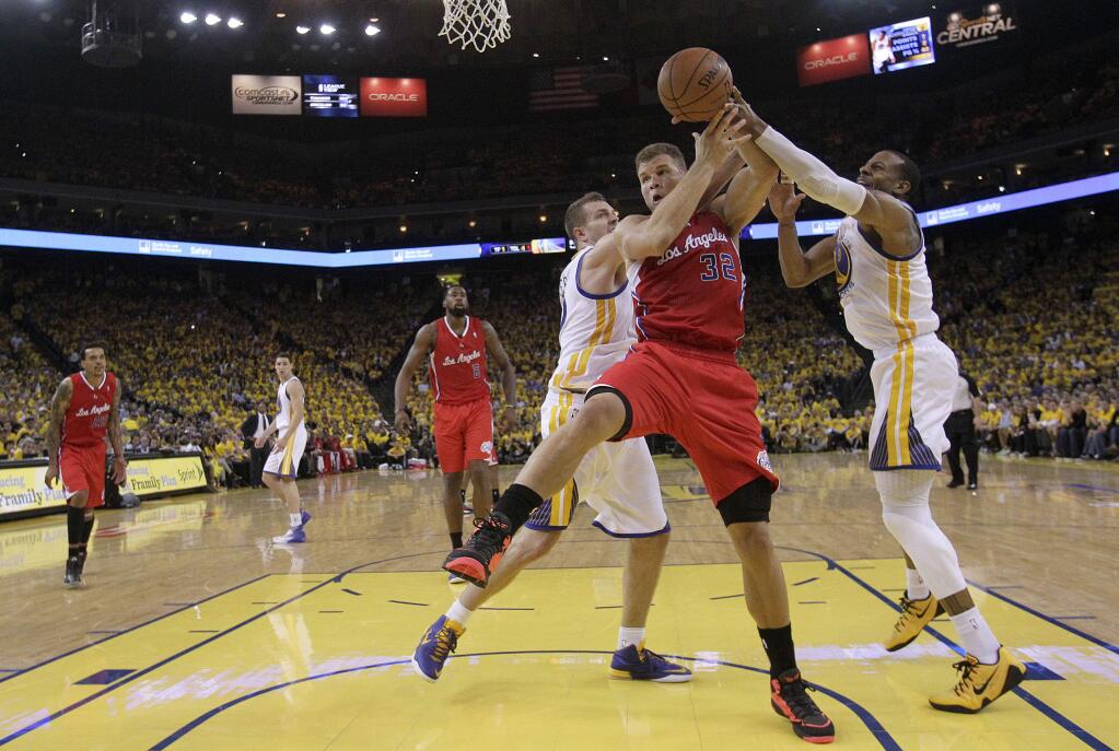 Los Angeles Clippers forward Blake Griffin (32) tries to control the ball as he is guarded by Golden State Warriors power forward David Lee, center left, and small forward Andre Iguodala during the second half of a playoff game in Oakland, Thursday, May 1, 2014. (AP Photo/Marcio Jose Sanchez)