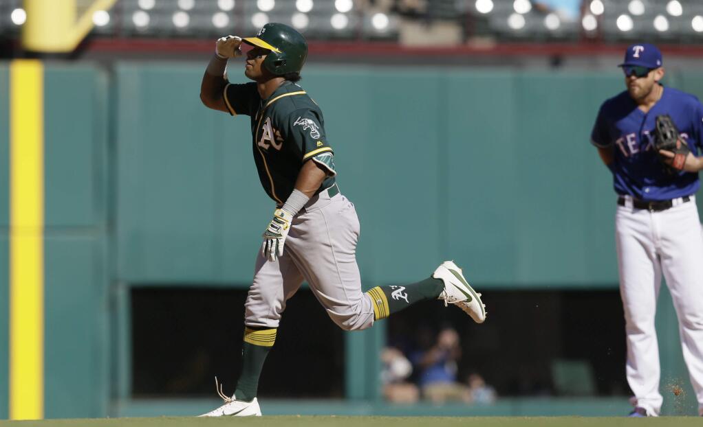 Oakland Athletics' Khris Davis salutes as he runs the bases after hitting a solo home run during the eighth inning of a baseball game against the Texas Rangers in Arlington, Texas, Sunday, Oct. 1, 2017. (AP Photo/LM Otero)