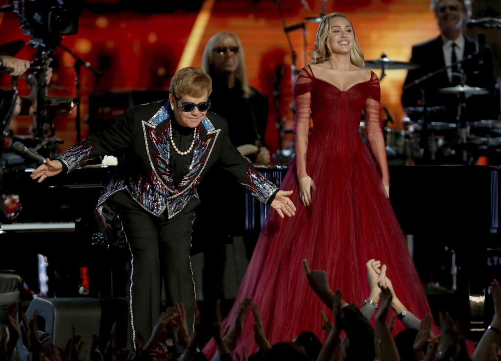 Elton John, left, and Miley Cyrus appear after a performance of 'Tiny Dancer' at the 60th annual Grammy Awards at Madison Square Garden on Sunday, Jan. 28, 2018, in New York. (Photo by Matt Sayles/Invision/AP)