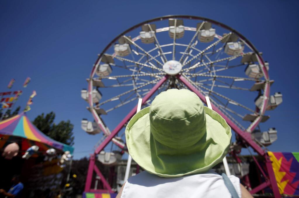 8/13/2012: B1:PC: Teresa Purroy looks up and watches as her great grandchildren ride the Ferris wheel on the last day of the Sonoma County Fair in Santa Rosa, California on Sunday, August 12, 2012. (BETH SCHLANKER/ The Press Democrat)