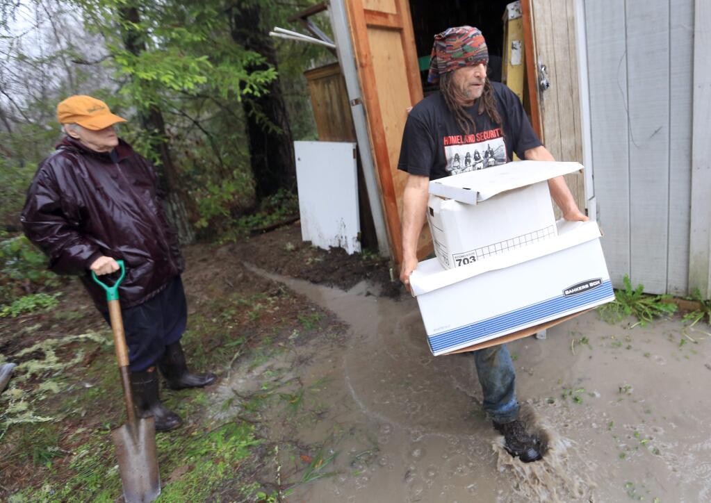 John Obertelli carries valuable papers of the Guerneville Community Church, Wednesday Dec. 10, 2014 to higher ground. (Kent Porter / Press Democrat) 2014