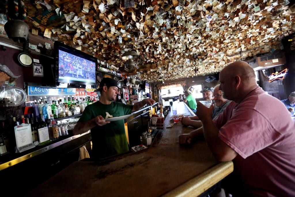 Bartender Ian Avery, left, clears plates from Ken Peters, right, Pete Bacigalupi, second from right and Chuck, third from right at the historic Washoe House on Stony Point Road in Petaluma, Wednesday, July 22, 2015. (CRISTA JEREMIASON / The Press Democrat)