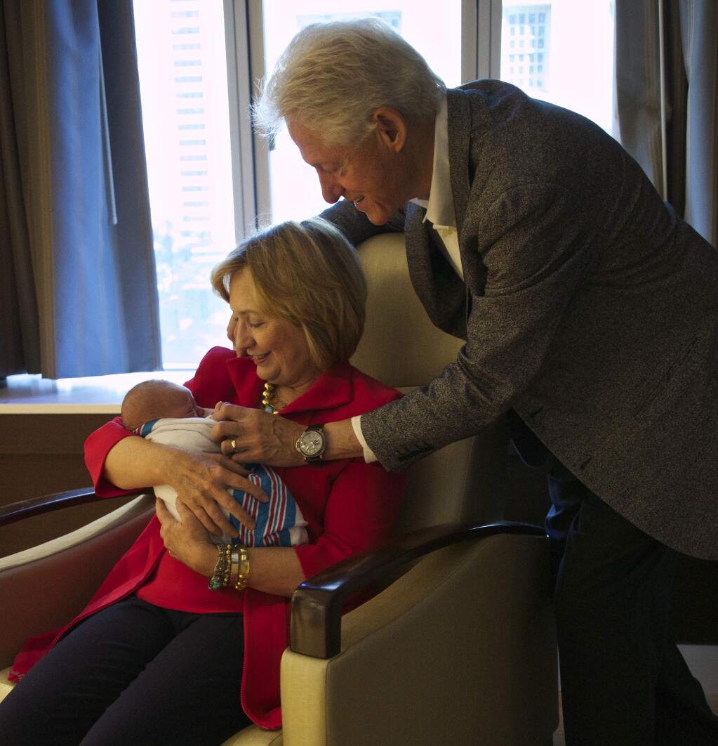 ADDS LOCATION This photo provided by Clinton spokesman Kamyl Bazbaz shows former Secretary of State Hillary Rodham Clinton, left, and former President Bill Clinton, right, with their granddaughter Charlotte Clinton Mezvinsky on Saturday, Sept. 27, 2014, at Lenox Hill Hospital in New York. The Clintons's daughter, Chelsea, gave birth Friday night to her first child, Charlotte. (AP Photo/Office of President Clinton, Jon Davidson)
