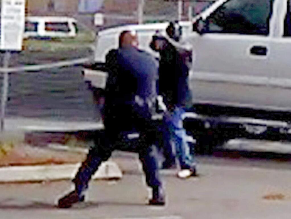 FILE - In this Sept. 27, 2016 file image made from from bystander video provided by the El Cajon Police Department, Alfred Olongo, right, is seen pointing what was later determined to be a bulky electronic cigarette device at El Cajon, Calif., police officer Richard Gonsalves during a confrontation at an El Cajon strip mall. Moments later Olongo was shot and killed. San Diego County District Attorney Bonnie Damais announced Tuesday, Jan. 10, 2017, that no criminal charges will be filed against Gonsalves. (El Cajon Police Department/San Diego County District Attorney's Office via AP, File)
