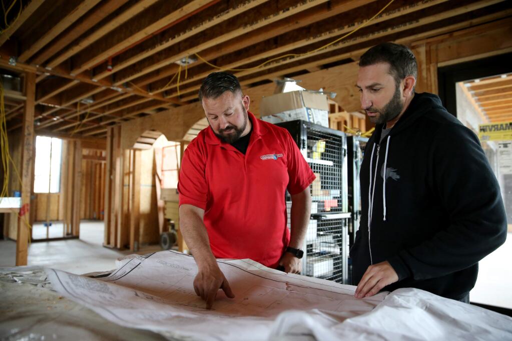 Joel Myer, the owner of All About Fire Protection, left, talks with construction manager Marwan Dada about the fire sprinkler placement at a Fountaingrove area home under construction in Santa Rosa on Tuesday, May 14, 2019. (BETH SCHLANKER/ PD)