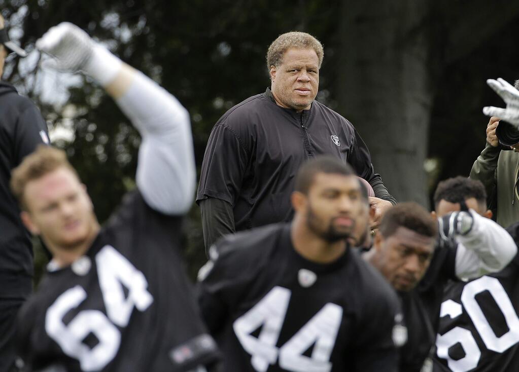 In this May 13, 2016, file photo, Oakland Raiders general manager Reggie McKenzie watches as players stretch during rookie minicamp in Alameda. (AP Photo/Jeff Chiu, File)