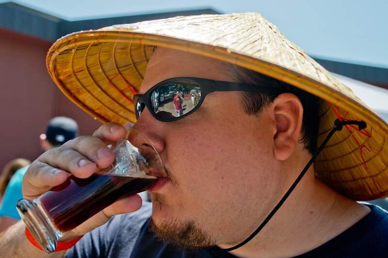 James Graham of Rohnert Park sips beer under the shade of his bamboo hat during Sonoma County Beerfest, a fundraiser for the Sonoma County AIDS Network, at the Wells Fargo Center for the Arts in Santa Rosa, California, on June 7, 2014. (Alvin Jornada / For The Press Democrat)
